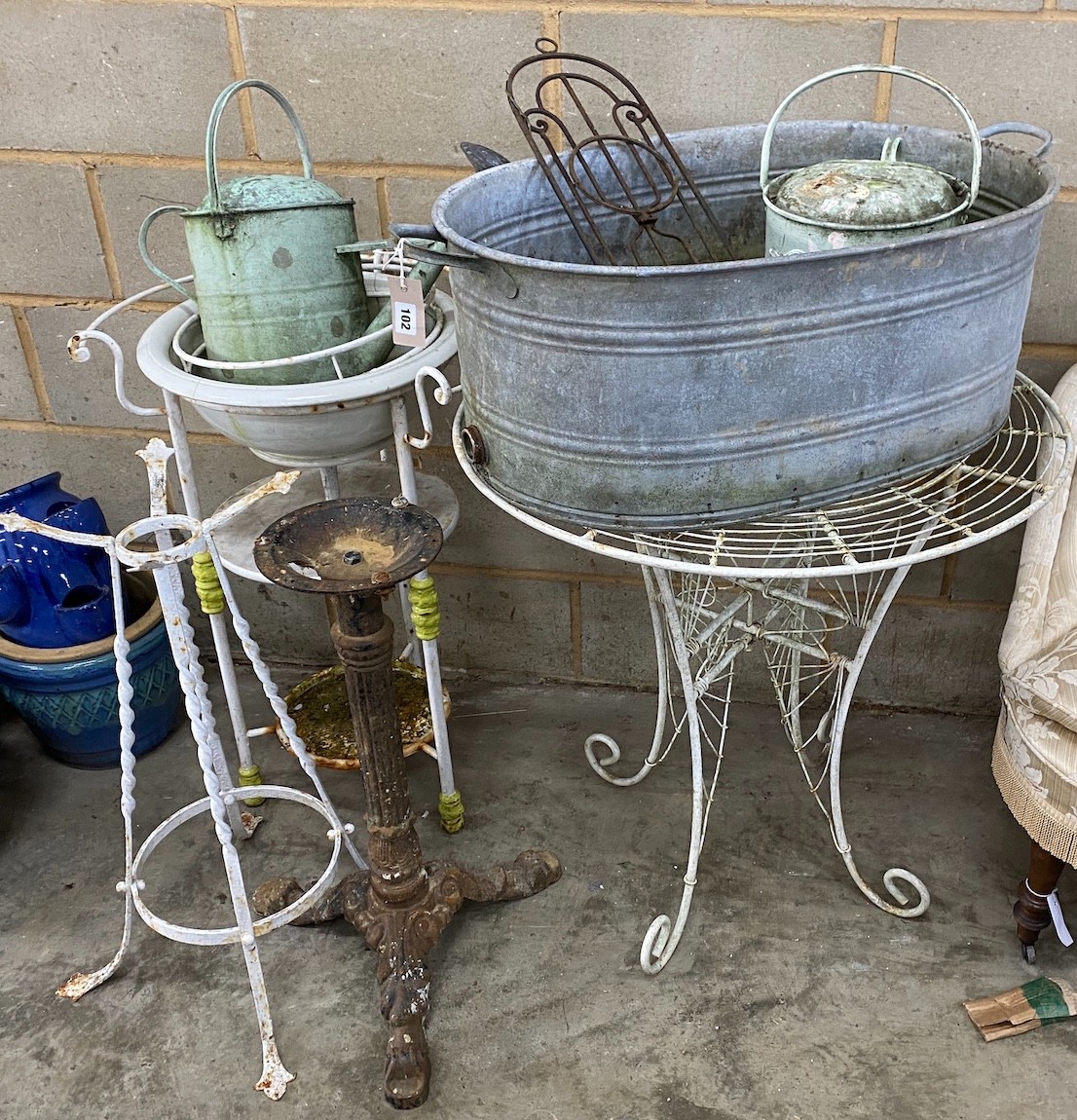 An oval galvanised water trough, a wrought iron washstand, garden table and sundry metalware